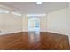 Open living space shows hardwood flooring and an arched doorway to another living area at 2209 Stonebridge Way, Clermont, FL 34711