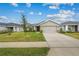 Single-story home with attached garage and landscaped lawn at 2311 Sunset Way, Davenport, FL 33837