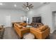 Living room with a large TV and comfortable orange leather couches at 2311 Sunset Way, Davenport, FL 33837