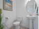 Small powder room with pedestal sink, toilet and decorative art at 2597 Mariotta Rdg, Clermont, FL 34715