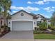 House exterior with gray siding, a large garage door and walkway at 2597 Mariotta Rdg, Clermont, FL 34715