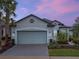 Beautiful two-story home with a gray exterior, two-car garage, and manicured landscaping at 2597 Mariotta Rdg, Clermont, FL 34715