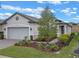 One-story home with gray siding, a large garage door, and landscaping at 2597 Mariotta Rdg, Clermont, FL 34715