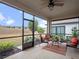 Relaxing screened porch with seating area and view of backyard at 2597 Mariotta Rdg, Clermont, FL 34715