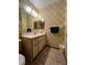 Small bathroom with a vanity, toilet and patterned wallpaper at 2620 Janet St, Kissimmee, FL 34741