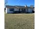 White single story home with teal shutters, spacious lawn, and driveway at 2620 Janet St, Kissimmee, FL 34741