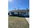 Front view of a single story home with teal accents and a well-maintained lawn at 2620 Janet St, Kissimmee, FL 34741