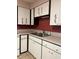 White cabinets and double sink in this well-lit kitchen at 2620 Janet St, Kissimmee, FL 34741