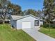 Aerial view of a light blue house with a driveway and green lawn at 26548 Deuce Ct, Leesburg, FL 34748