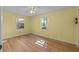 Spacious bedroom with wood flooring and two windows at 26548 Deuce Ct, Leesburg, FL 34748