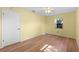 Well-lit bedroom with wood floors and a ceiling fan at 26548 Deuce Ct, Leesburg, FL 34748