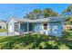 Side view of a light blue house with a screened porch and lush green lawn at 26548 Deuce Ct, Leesburg, FL 34748