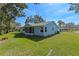 Light blue house with a screened porch and grassy yard at 26548 Deuce Ct, Leesburg, FL 34748