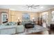 Spacious living room featuring a light teal sectional sofa and wood flooring at 26715 Manassas Dr, Leesburg, FL 34748