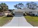 Front view of a single-story house with a two-car garage and well-manicured lawn at 26912 Tanner St, Leesburg, FL 34748