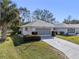 Exterior view of a house with a screened-in garage and landscaping at 26912 Tanner St, Leesburg, FL 34748