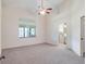 Spacious bedroom featuring a large window above the bed and an open doorway to the en suite bathroom at 26913 Racquet Cir, Leesburg, FL 34748