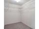 Walk-in closet with metal shelving on three walls; ready to be stocked and organized at 26913 Racquet Cir, Leesburg, FL 34748