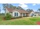 Tan one-story house with brown roof and screened garage at 26913 Racquet Cir, Leesburg, FL 34748