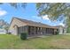 Rear view of house, showcasing screened-in patio and yard at 26913 Racquet Cir, Leesburg, FL 34748