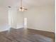 Open-concept living room with wood floors, ceiling fan, and neutral paint, offering a versatile space at 26913 Racquet Cir, Leesburg, FL 34748