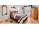 Bright bedroom with wood floors, a double bed, and a large wooden dresser at 2954 Silk Tree Ter, The Villages, FL 32163