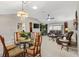 Open dining area with glass table and leather living room furniture at 2954 Silk Tree Ter, The Villages, FL 32163