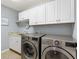 Laundry room with LG washer and dryer, white cabinets, and granite countertop at 2954 Silk Tree Ter, The Villages, FL 32163