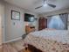 Main bedroom with a floral comforter, dresser, and large TV at 30111 Pga Dr, Mount Plymouth, FL 32776