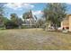 Large backyard with mature trees and a screened porch at 32125 Mark Ave, Tavares, FL 32778