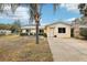 Cute yellow house with palm tree, driveway, and grassy yard at 32125 Mark Ave, Tavares, FL 32778