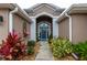 Front entry with a blue door, and nicely landscaped walkway at 3257 Triton Ct, The Villages, FL 32163