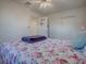 Bedroom with floral bedding, ceiling fan, and access to bathroom at 33648 Picciola Dr, Fruitland Park, FL 34731