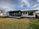 Back exterior view showing the house and a well-maintained lawn at 33648 Picciola Dr, Fruitland Park, FL 34731