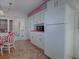 White kitchen features pink countertops and a full-size refrigerator at 33648 Picciola Dr, Fruitland Park, FL 34731