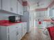 Full view of a white kitchen with pink countertops and a microwave at 33648 Picciola Dr, Fruitland Park, FL 34731