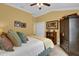 Bedroom featuring an armoire, ceiling fan, and a large bed with decorative pillows at 3545 Lia Ln, The Villages, FL 32163