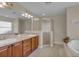 Spacious bathroom featuring double sinks, a glass enclosed shower, and a soaking tub at 35808 Rose Moss Ave, Leesburg, FL 34788