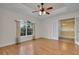 Spacious bedroom with wood look tile floors, tray ceiling, fan and large arched window at 35808 Rose Moss Ave, Leesburg, FL 34788