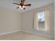 Neutral bedroom with tile floors, ceiling fan and large window for natural light at 35808 Rose Moss Ave, Leesburg, FL 34788