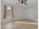 Bedroom with a ceiling fan, closet, neutral walls and tile floors at 35808 Rose Moss Ave, Leesburg, FL 34788