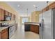 Open kitchen with stainless steel appliances and tile flooring, flowing into a brightly lit dining area at 35808 Rose Moss Ave, Leesburg, FL 34788