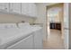 Bright laundry room featuring a washer, dryer, and access to a sunny kitchen at 35808 Rose Moss Ave, Leesburg, FL 34788