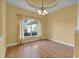 Elegant living room with wood floors, bright windows, and decorative curtains, creating a cozy atmosphere at 35808 Rose Moss Ave, Leesburg, FL 34788