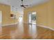 Bright living room featuring wood floors, neutral walls, and access to the outdoor patio at 35808 Rose Moss Ave, Leesburg, FL 34788