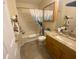Bathroom with shower-tub, tiled floors, granite vanity, and decorative accents at 3621 Amelia Ave, The Villages, FL 32162