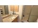 Well-lit bathroom featuring granite countertop, a mirrored vanity, and a glass-door shower at 3621 Amelia Ave, The Villages, FL 32162