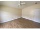 Bright bedroom with wood-look flooring, ceiling fan, and neutral-colored walls at 3621 Amelia Ave, The Villages, FL 32162