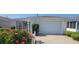 Charming home featuring a one-car garage, screened porch, and a vibrant flower garden in front at 3621 Amelia Ave, The Villages, FL 32162