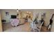 Open-concept living and dining area with wood floors, modern decor, and a view into the kitchen at 3621 Amelia Ave, The Villages, FL 32162